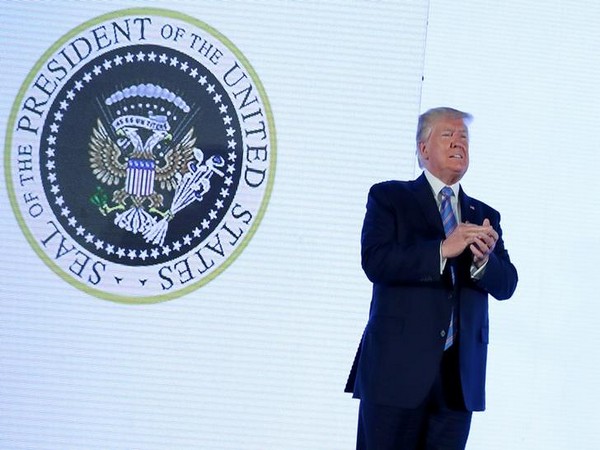 US President Donald Trump takes on stage  next to an altered presidential seal prior to a speech at Turning Point USA's Teen Student Action Summit.