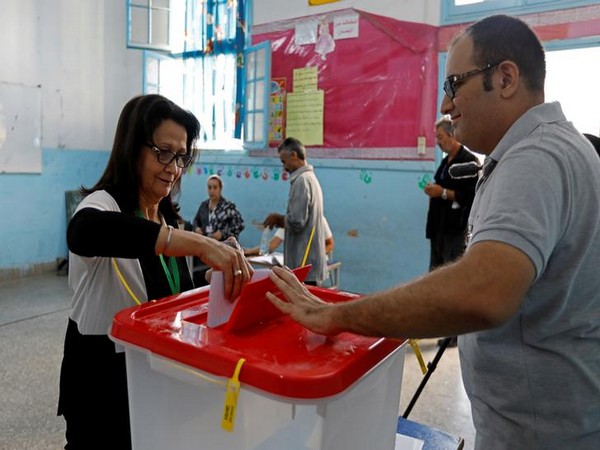 A woman casts her ballot at a polling station during parliamentary elections in Tunis