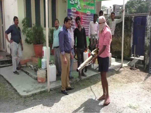 Delhi trainer (in purple shirt) giving traning to an official of Nainital state department on how to do fogging to control the spread of Dengue. [Photo/ANI]