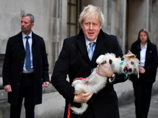  British prime minister Boris Johnson, accompanied by his dog Dylan, leave a polling station after casting ballot in the UK general elections on Thursday 