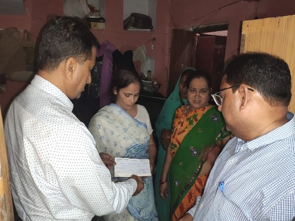 Officials handing over a cheque to Kamlesh Tiwari's wife in Sitapur, Uttar Pradesh on Wednesday. 