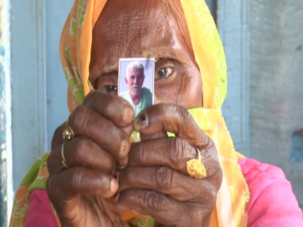 A villager of Kanpur Dehat holding the picture of her late husband (Photo/ANI)