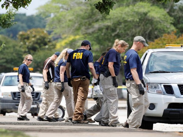 FBI members search a parking lot outside a municipal government building where a shooting incident occurred in Virginia Beach on Friday. (Photo courtesy:Reuters)