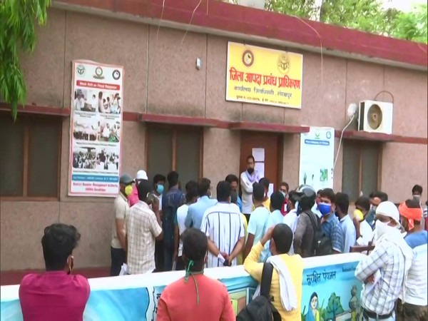 Relatives of COVID-19 patients wait outside a dispensary in Gorakhpur. (Photo/ANI)