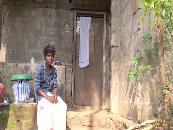 A man sits outside his residence in the tribal village of Avanipara in Kerala. (Photo/ANI)