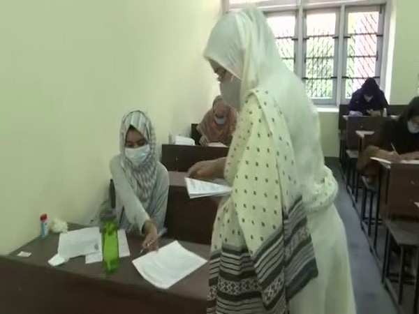 An invigilator hands out the question paper for the entrance exam at SKUAST. (Photo/ANI)