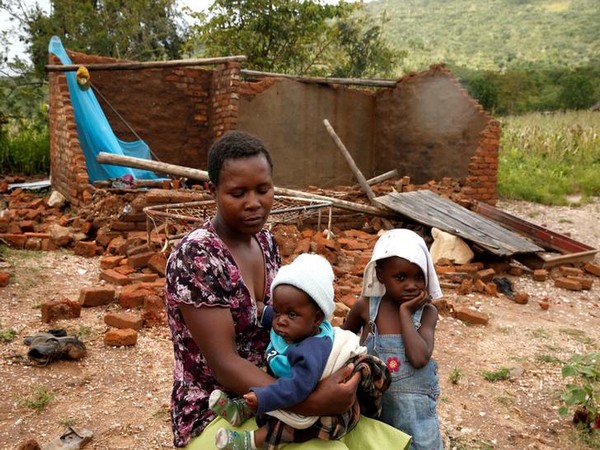 A family in front of their destroyed home following Cyclone Idai in Chimanimani district, Zimbabwe on March 18