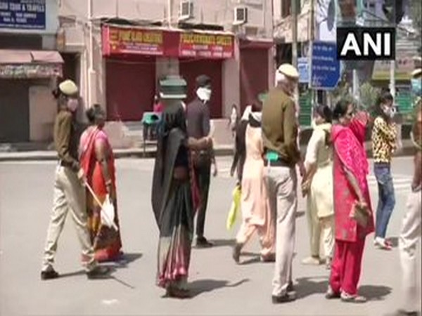 Police personnel disperse women outside a bank in Paharganj. Photo/ANI