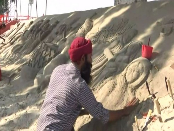 Artist creating Ramayana episodes on sand. (Pht