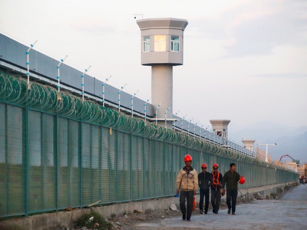 Workers walk by the perimeter fence of what Beijing says a vocational skills education centre in Dabancheng in Xinjiang Uighur Autonomous Region, China, September 4, 2018. (Image credit: Reuters) 