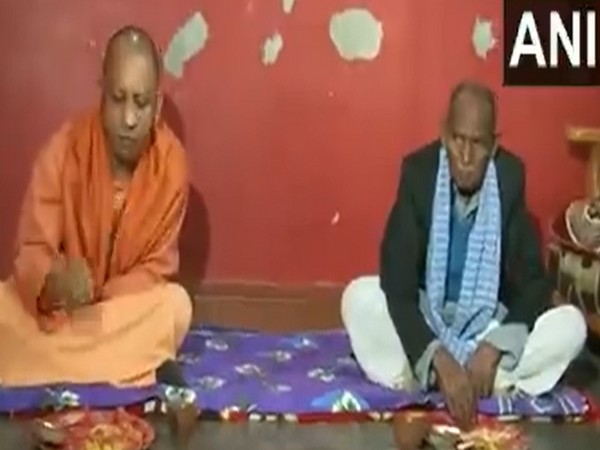 Visual of Yogi Adityanath while having lunch at the house of Dalit party worker (Photo/ANI) 