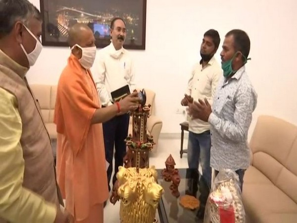 UP Chief Minister Yogi Adityanath with clay artisans at his residence on Friday. (Photo/ANI)