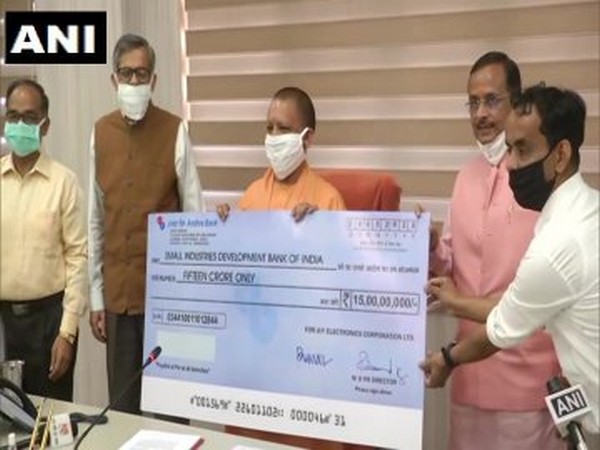 Uttar Pradesh Chief Minister Yogi Adityanath presenting a cheque to SIDBI officials in Lucknow on Wednesday. [Photo/ANI]