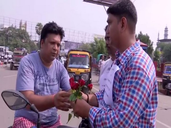 Krishna Kumar Singh distributed flowers to people who were driving without helmet or seat belt in Bihar's Patna on Saturday. Photo/ANI