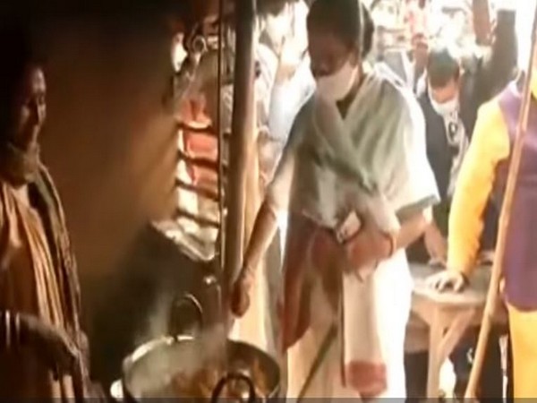 Chief Minister Mamata Banerjee helping a tribal woman cook at a small hotel in  Ballavpur Danga Village